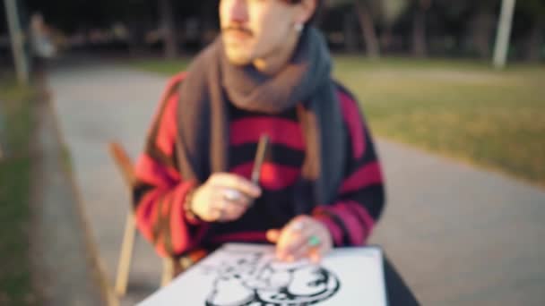 Modern young stylish male paint artist drawing sketches in park — 비디오