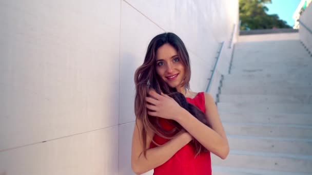 Hermosa mujer en vestido elegante rojo. Fondo blanco urbano — Vídeo de stock