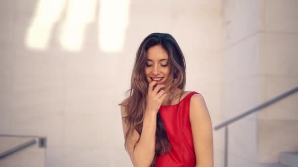 Beautiful woman in red elegant dress. Urban white background — Stock Video