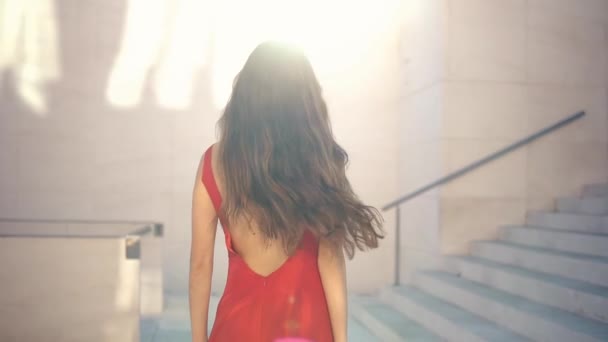 Kırmızı zarif elbiseli güzel bir kadın. Şehir beyaz arka planı — Stok video