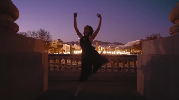 Jeune ballerine professionnelle en robe noire danse en plein air — Video