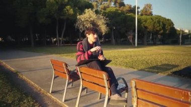 Modern genç stil erkek boyacı parkta çizimler yapıyor.