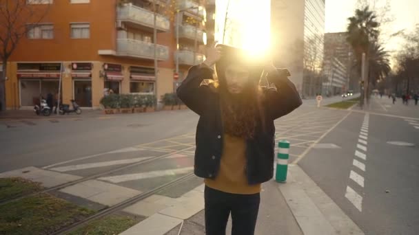 Retrato de hipster de pelo largo caminando por la calle en la ciudad moderna — Vídeo de stock