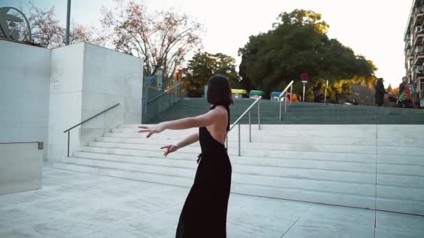 Ung professionell ballerina i svart klänning dansar utomhus — Stockvideo