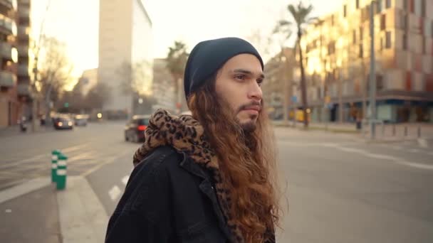 Portré hosszú hajú hipster séta az utcán a modern városban — Stock videók