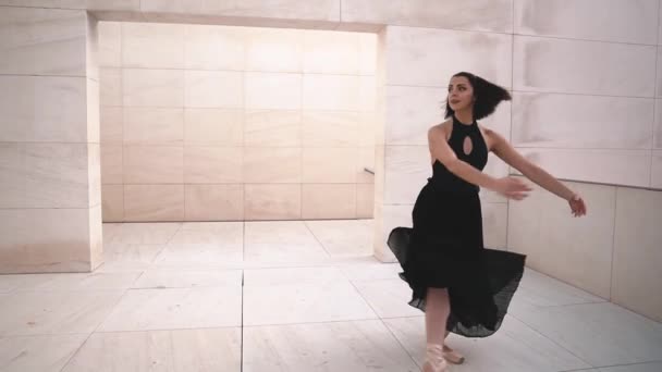 Молода професійна балерина в чорній сукні танцює на відкритому повітрі — стокове відео