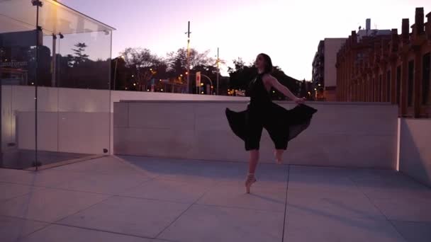 Joven bailarina profesional en vestido negro está bailando al aire libre — Vídeo de stock