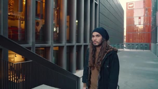 Portrait of long haired hipster walking on street in modern city — 비디오