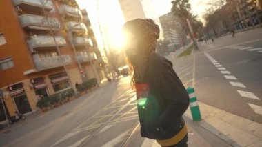 Modern şehirde sokakta yürüyen uzun saçlı hippi portresi.