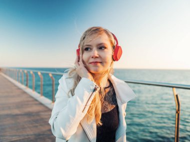 Gün batımında güzel sahil köprüsü terasında yürüyen bir kadın.