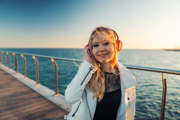 Woman walking along beautiful beach bridge terrace at sunset — 스톡 사진