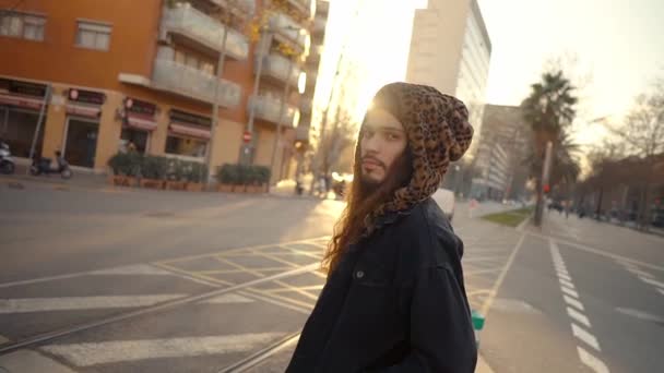 Retrato de hipster de pelo largo caminando por la calle en la ciudad moderna — Vídeo de stock