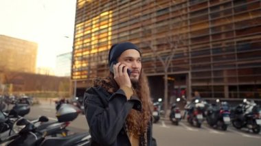 Modern şehirde sokakta yürüyen uzun saçlı hippi portresi.