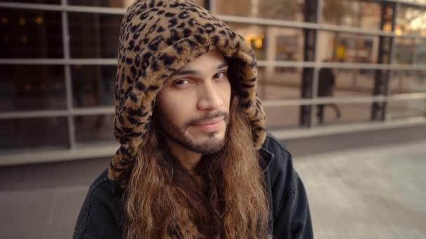 Retrato de hipster de pelo largo caminando por la calle en la ciudad moderna — Vídeo de stock