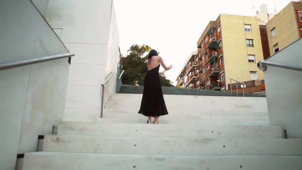 Молодая профессиональная балерина в черном танцует на открытом воздухе — стоковое видео