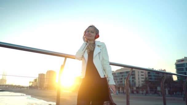 Mujer caminando a lo largo de hermosa terraza puente de playa al atardecer — Vídeos de Stock