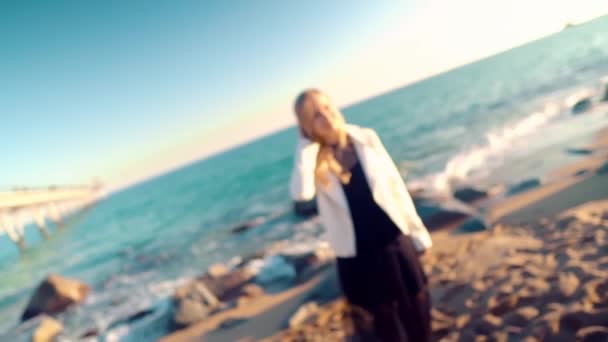 Молодая женщина, гуляющая по прекрасному океанскому пляжу на закате — стоковое видео