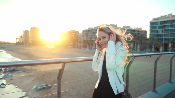 Mujer caminando a lo largo de hermosa terraza puente de playa al atardecer — Vídeos de Stock