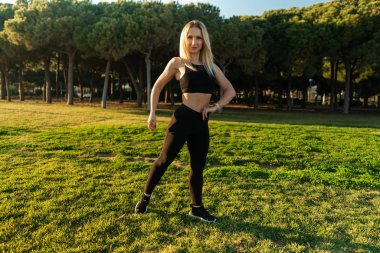 Şehir parkında spor eğitimi. Güzel koşucu kadın poz veriyor