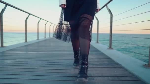 Mujer caminando a lo largo de hermosa terraza puente de playa al atardecer — Vídeo de stock