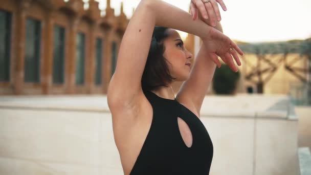 Jovem bailarina profissional em vestido preto está dançando ao ar livre — Vídeo de Stock