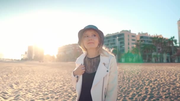 Ung kvinna går på vacker havsstrand vid solnedgången — Stockvideo