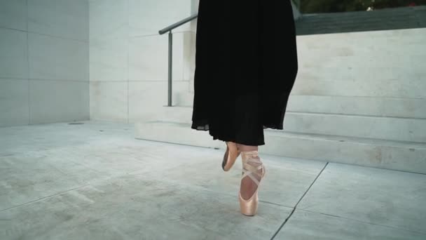 Young professional ballerina in black dress is dancing outdoors — Stock Video