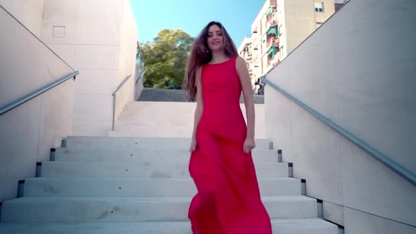 Όμορφη γυναίκα με κόκκινο κομψό φόρεμα. Λευκό αστικό φόντο — Αρχείο Βίντεο
