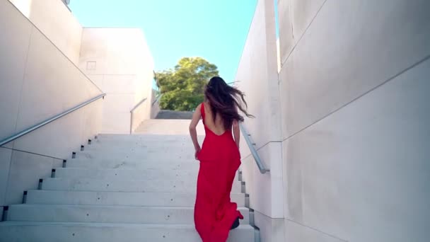 Beautiful woman in red elegant dress. Urban white background — Stock Video