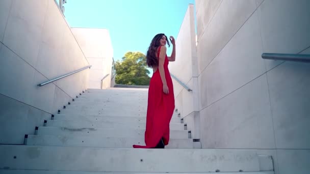 Hermosa mujer en vestido elegante rojo. Fondo blanco urbano — Vídeos de Stock