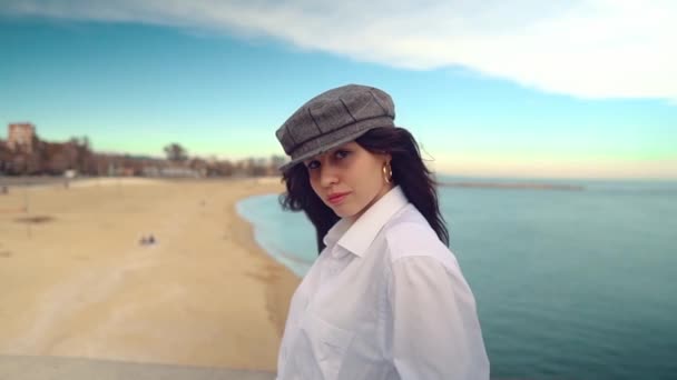 Портрет молодої красивої стильної жінки в білій сорочці і сірій шапці — стокове відео