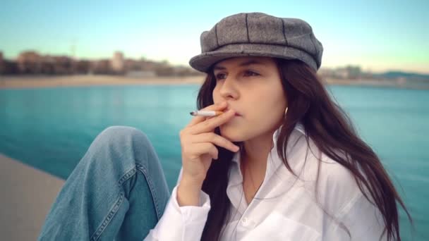 Portrét mladé krásné stylové ženy v bílé košili a šedé čepici — Stock video