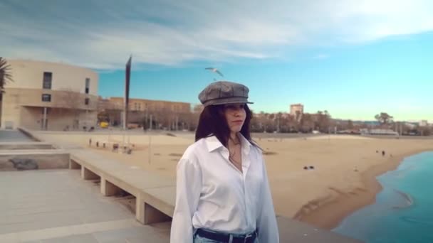 Портрет молодої красивої стильної жінки в білій сорочці і сірій шапці — стокове відео