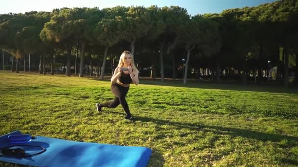Спортивная тренировка в городском парке. Красивая белая стройная женщина на открытом воздухе — стоковое видео