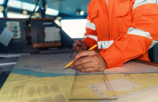 Ufficiale di coperta filippino sul ponte di nave o nave. Sta tracciando la posizione sul grafico. — Foto Stock