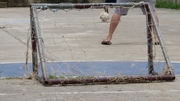 Pool pojke sparkar gamla fotboll har laceration och netto laceration små mål med man. — Stockvideo