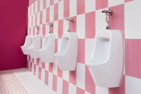 Pisuar biały z różowe płytki w WC mężczyzn. — Zdjęcie stockowe