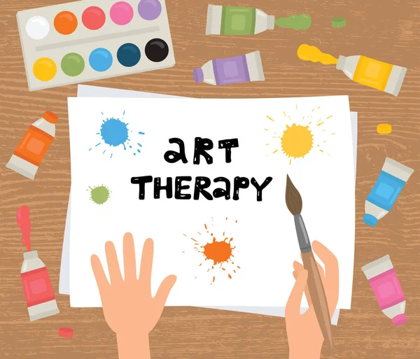 Kunsttherapie. Hände, Pinsel, Farbe, Blatt Papier auf Holzgrund. — Stockvektor