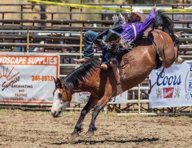 Eyersiz kovboy tutunarak
