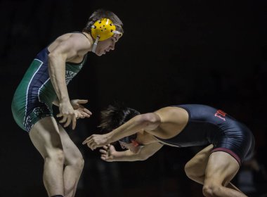 Wrestling action with Red Bluff vs. Foothill High School under the spotlight in Palo Cedro, California. January 10, 2018.  clipart