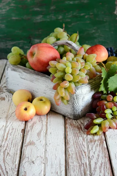 Holzkiste mit duftenden reifen Äpfeln und Trauben Obstkorb Bio — Stockfoto