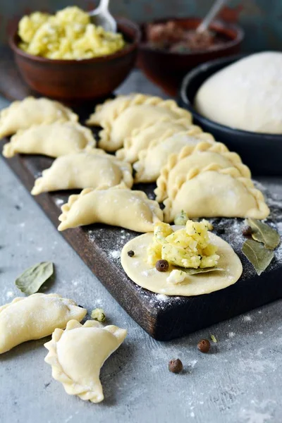 Mavi arka planda patatesli hamur tatlısı. Varenyky, vareniki, pierogi, pyrohy - dolgulu hamur tatlısı.