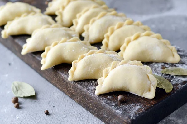 Mavi arka planda patatesli hamur tatlısı. Varenyky, vareniki, pierogi, pyrohy - dolgulu hamur tatlısı.