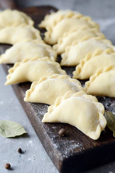 Mavi arka planda patatesli hamur tatlısı. Varenyky, vareniki, pierogi, pyrohy - dolgulu hamur tatlısı.