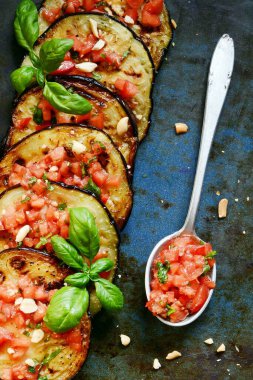 Domatesli ızgara patlıcan ve taze fesleğen yanında ezilmiş ceviz, zeytinyağı ve domates sosu..