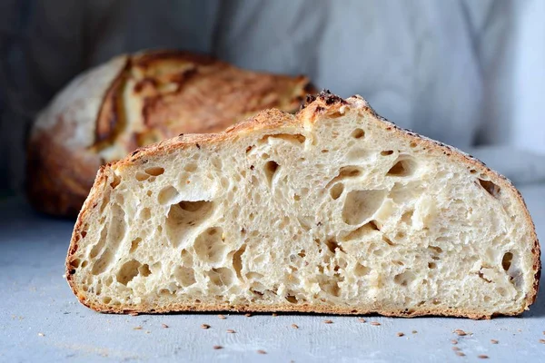 Homemade Freshly Baked Country Bread  made from wheat and whole grain flour on a gray-blue background. French Freshly baked bread. Slicing homemade bread