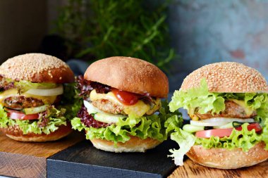 Sulu pirzola, yeşil salata, peynir ve sebzeli taze lezzetli hamburgerler. Ev yapımı hamburger..