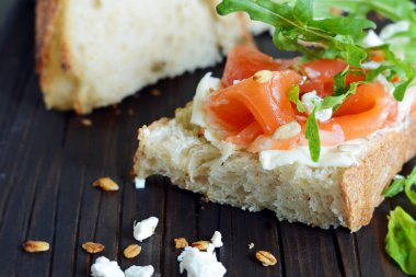 Biraz tuzlanmış somon, roka, tohum ve süzme peynirli sandviç. Ekmekli tost, tuzlu balık, smorrebrod.