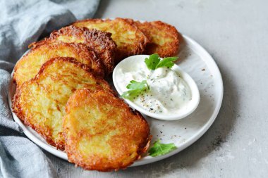 Yeşil salata ve yoğurt soslu çıtır patates krep. Patates böreği yığını
