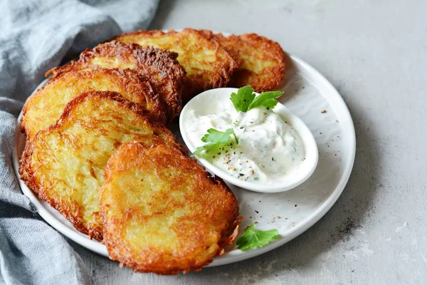 Yeşil salata ve yoğurt soslu çıtır patates krep. Patates böreği yığını